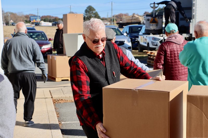 Bob Blouin, Clothing Our Kids president, helps move boxes filled with donated sneakers. Blouin said the shipment retails at $50,000. He said 1,000 pairs of sneakers will last until the end of the school year.